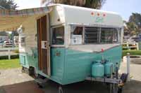 Photo of a vintage 1964 Shasta trailer showing new metal screen door and front profile first introduced in 1958